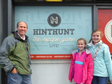 Family standing next to the HintHunt sign