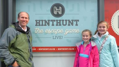 Family standing next to the HintHunt sign