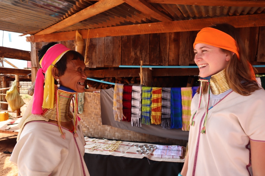 Long Neck Paduang woman laughs with tourist in Kayan village in Myanmar